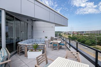 A patio with a table and chairs overlooking a street.